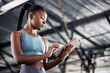 © Michael Cunningham/peopleimages.com - Black woman, typing or personal trainer with a tablet for fitness training, workout or sports exercise. Progress results, digital technology app or gym instructor planning a online coaching schedule