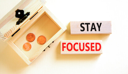 Stay focused symbol. Concept words Stay focused on wooden blocks on a beautiful white background. Wooden chest with coins. Business, support, motivation, psychological stay focused concept. Copy space