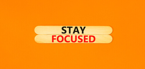 Stay focused symbol. Concept words Stay focused on beautiful wooden stick on a beautiful orange table orange background. Business, support, motivation, psychological stay focused concept. Copy space.