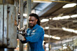 © KANGWANS - African American male worker working with industrial machinery in heavy industry. Maintenance and repairing work in modern industry concept.