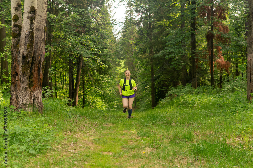 young woman jogging on a trail in a natural forest park Stock Photo ...