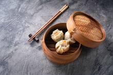 Chinese Steamed Dumplings Or  Dim Sum In Bamboo Steamer On Dark Abstract Background