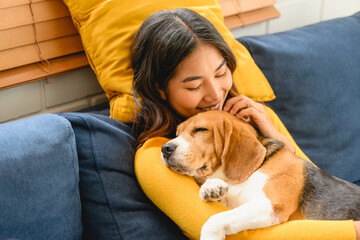 a woman is shown in a friendly interaction with her dog, a playful beagle