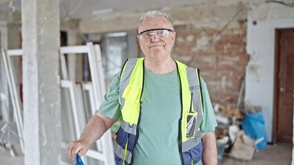 Poster - Middle age grey-haired man builder smiling confident taking out hardhat at construction site