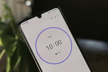 a phone with a black and white 10-minute timer to study with the pomodoro method on a blurry backgro