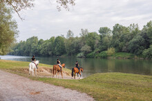 Three Female Riders Enjoying Riding Horses In The Beautiful Nature, Stepping Down To The River Water. Leisure And Recreational Riding Concept.