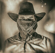 Old west bandit outlaw with covered face and cowboy hat, edited in vintage film style.