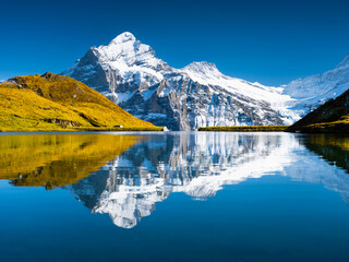 Canvas Print - Swiss landscape. High mountains and reflection on the surface of the lake. Mountain valley with lake. Landscape in the highlands in the summertime. Travel and vacation.