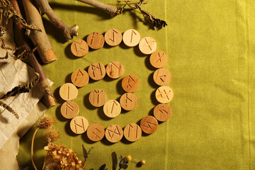 Wall Mural - Many wooden runes and dried plants on olive fabric, flat lay. Space for text