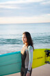 © amanaimages - サーフボードを抱えている女性