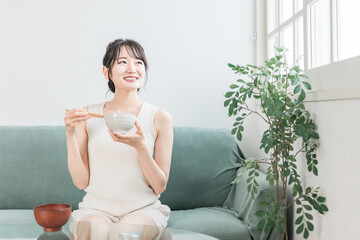 家で朝食・朝ごはんを食べる若いアジア人女性（白米・ご飯）
