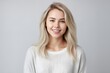 Headshot of a beautiful blond smiling young woman looking at the camera on gray background. Generative AI
