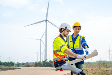 Wall Mural - Group of engineers are working with a blueprint in wind turbine farm,Wind power station,Renewable and clean energy concept.