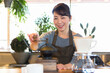 © amanaimages - コーヒー豆を挽く女性