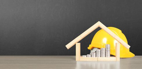 Yellow hardhat model house and coin with trading graph