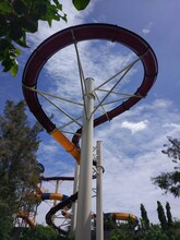 Waterslide Track From Below In The Park With Blue Sky And White Clouds