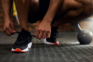 Canvas Print - Tie shoes, man hands and gym floor for fitness, strength training and exercise. Athlete feet, sport routine and male person prepare to start workout and wellness class at health center with sneakers