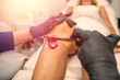 © RomanR - young female client doing epilation with shugaring pasta wax removing unwanted hair on leg in spa salon.