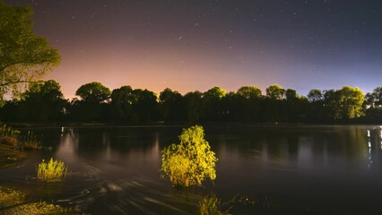 Wall Mural - Meditation By The Water. 4k Hyperlapse Meteors Fly Across The Night Sky. Night Sky Above River. From Dusk To Dawn. Stars Float Across Sky. Night Sky Turns Into Morning. Dawn Is Coming. Calmness And
