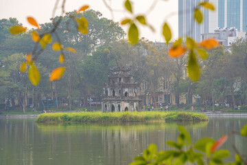 Wall Mural - Hoan Kiem Lake ( Ho Guom) or Sword lake in the center of Hanoi in the fog in the morning. Hoan Kiem Lake is a famous tourist place in Hanoi. Travel and landscape concept. Selective focus.