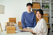 © bongkarn - A successful young Asian couple, small online business owners are in their home office