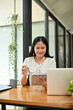 © bongkarn - Happy young Asian female assistant checking her meeting schedule on her digital tablet