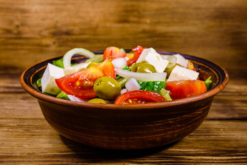 Wall Mural - Ceramic plate with greek salad on wooden table