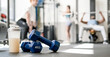 Dumbbells with bottle of protein drink placed on floor in sports club