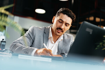 Poster - Young arab businessman working at the table in modern office