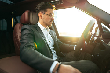 Poster - Young businessman in elegant suit driving luxury car