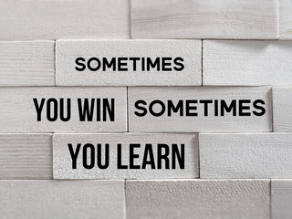 Wall Mural - Inspirational and Motivational Concept - 'sometimes you win sometimes you learn' text on wooden blocks background.