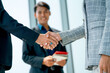 © narong - Close up business man and woman shake hands together in front of business man with smiling show success of cooperation together in the project of company with day light.