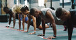 © Armand Burger/peopleimages.com - Teamwork, fitness and people do push up in gym for training, exercise and workout class. Health, sports club and serious group of men and women body builders for challenge, wellness and strength