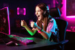 © alexkoral - happy girl an esports player behind the monitor is happy to win an cybersports game competition. Generative AI