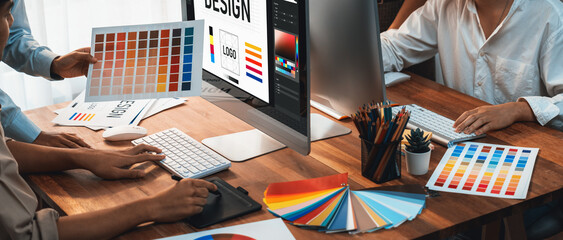 Poster - Graphic designer work on computer laptop and with graphic drawing pen while brainstorming unique design with professional graphic team in modern digital studio workplace. Panorama shot. Scrutinize