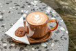Cup of cappuccino with latte art with two chocolate biscuit high angle view