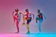 © master1305 - Sport show. Three funny men in colorful sportswear doing aerobics exercises against gradient blue pink studio background in neon light. Concept of sportive and active lifestyle, humor, retro style. Ad