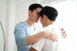 © janonkas - happy gay couple in love spending time together tender moments in living room. Homosexual love relationship and gender equality
