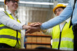 © Yingyaipumi - Unity and success concept.Bottom view of Engineer team people standing hands holding together at the warehouse.Engineer,worker and businessman Team Stacking Hands.Panoramic banner.