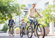 © KOTO - Mother and son in helmets riding tandem bicycle in urban park