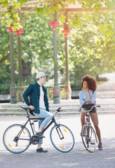 Wall Mural - Friends on bicycles talking in urban park