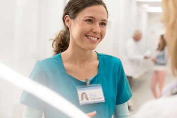 Wall Mural - Smiling nurse talking to doctor in hospital corridor