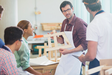 Teacher and students in adult education carpentry workshop class