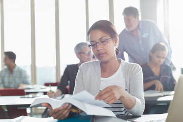 Student reading textbook in adult education classroom