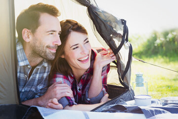 Wall Mural - Smiling couple peering from inside tent