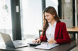 © Nuttapong punna - Woman freelancer is working her job on computer tablet and laptop Doing accounting analysis report real estate investment data, Financial at office.