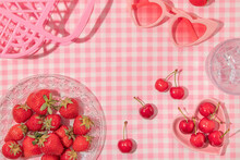 Summer Creative Layout With Strawberries, Cherries, Glass With Ice Cubes, Heart Sunglasses And Handbag On Pastel Pink Plaid Background. 80s Or 90s Retro Aesthetic Idea. Minimal Summer Fruit Idea.