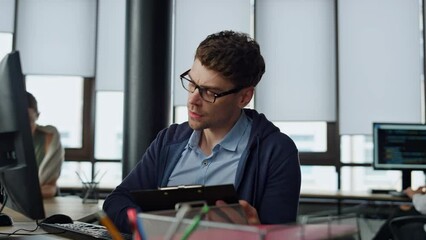 IT manager analysing online report. Thoughtful software engineer making notes
