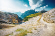 © Michael - Young sportive woman walks along scenic Dolomites high trail in the evening. Tre Cime, Dolomites, South Tirol, Italy, Europe.