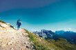 © Michael - Young sportive woman walks along scenic Dolomites high trail in the evening. Tre Cime, Dolomites, South Tirol, Italy, Europe.